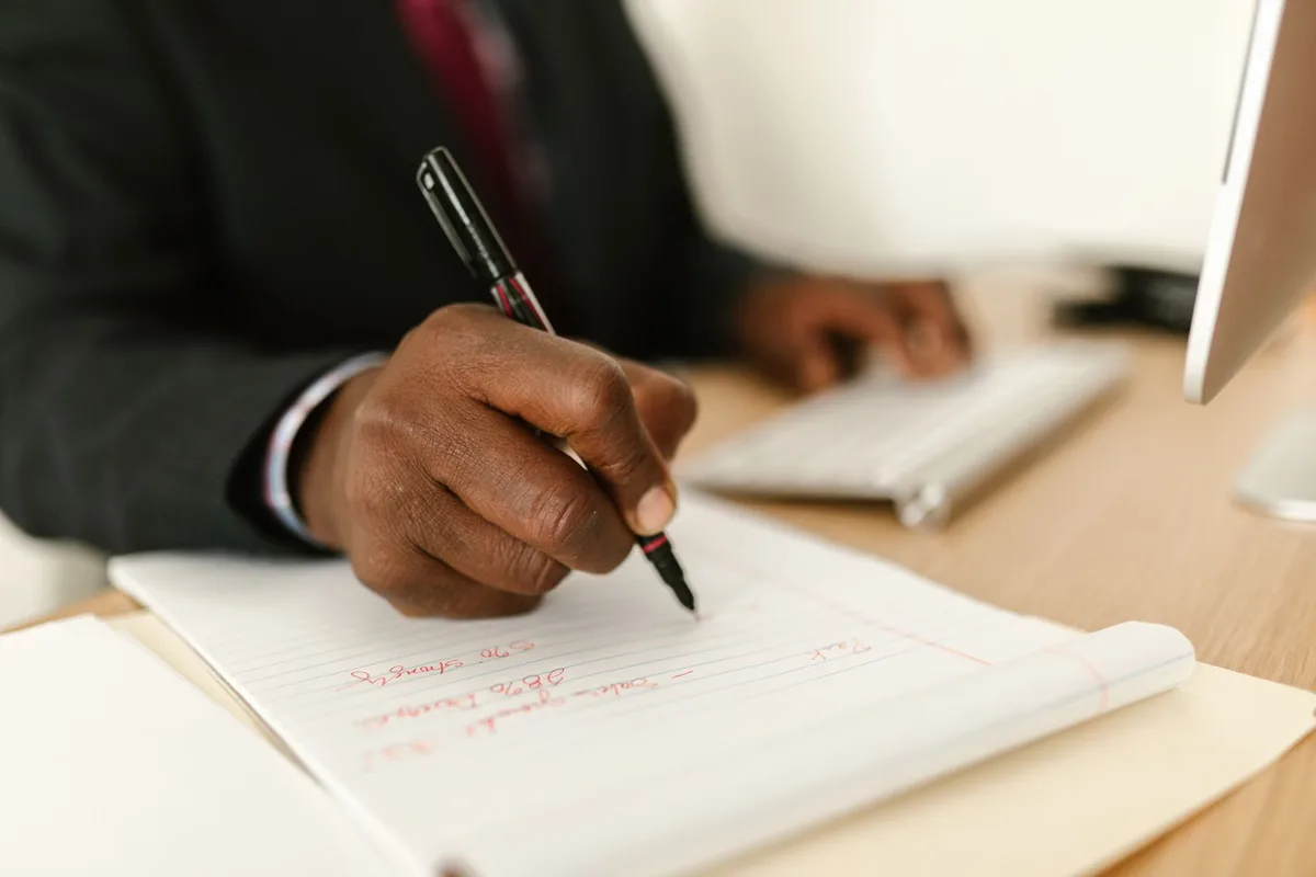 Un candidat prend des notes et prépare ses réponses pour un entretien d'embauche