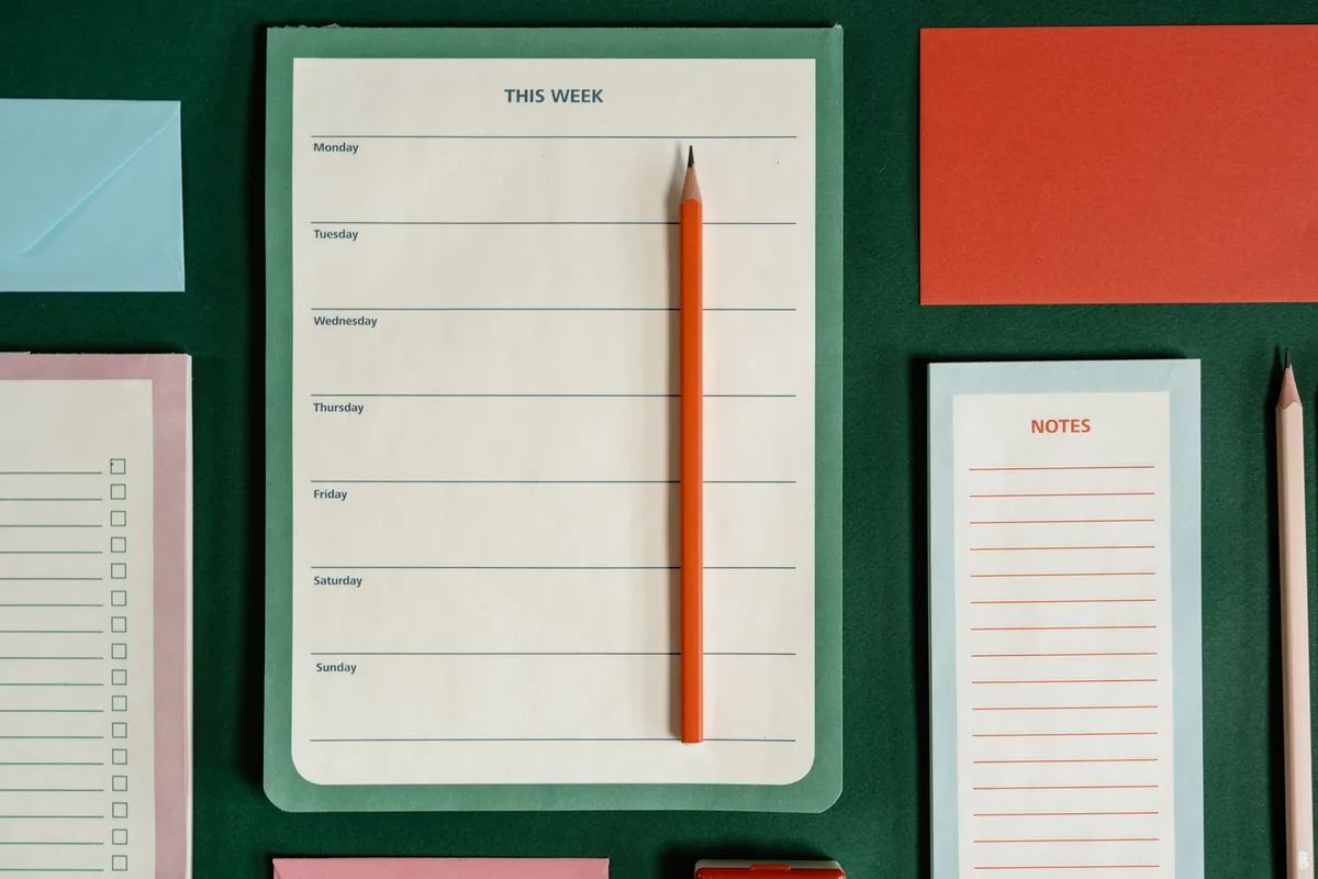 Parent avec fournitures scolaires et calendrier de rentrée sur un bureau professionnel