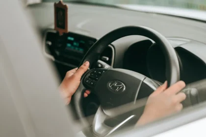 Intérieur de voiture hybride rechargeable avec tableau de bord éclairé et mains sur le volant