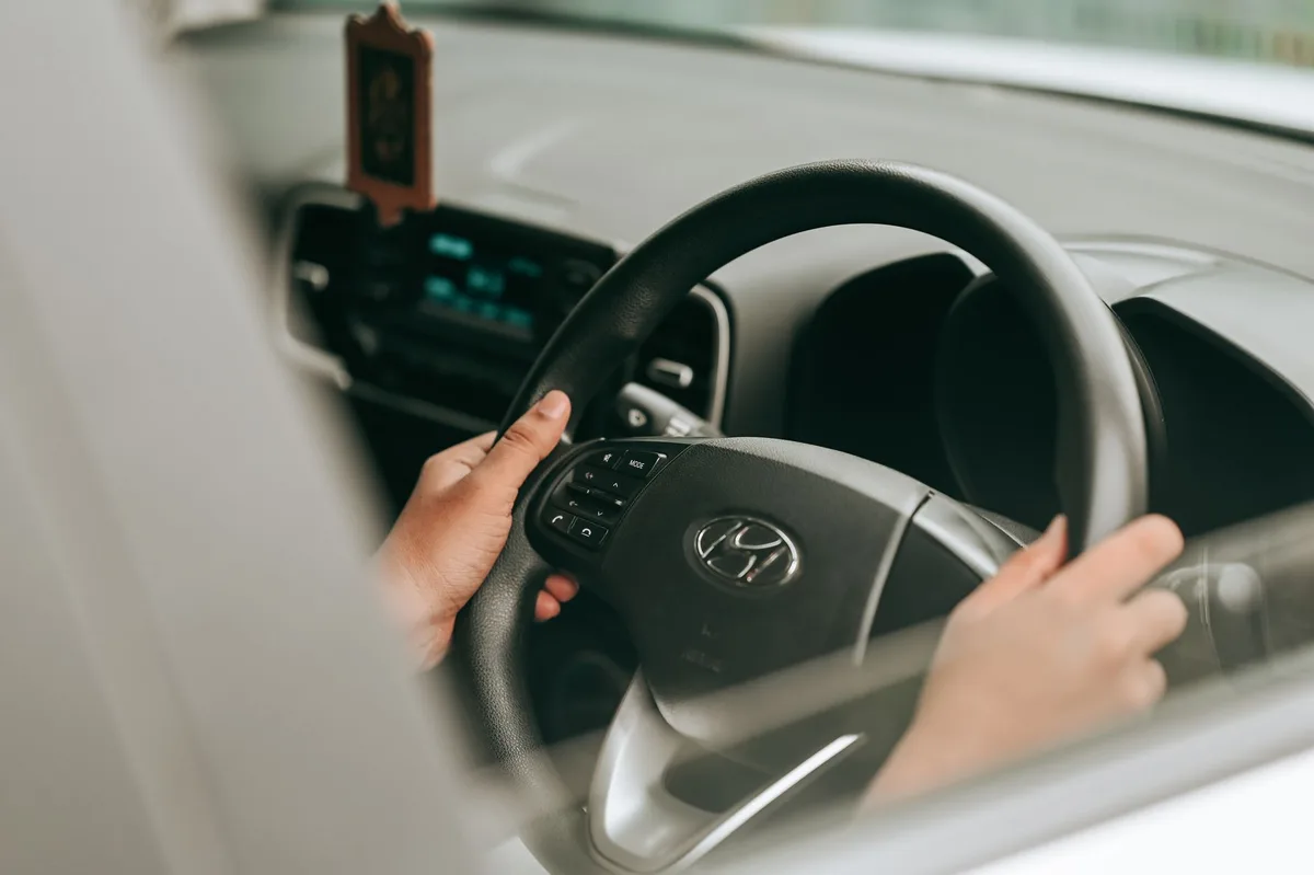 Intérieur de voiture hybride rechargeable avec tableau de bord éclairé et mains sur le volant