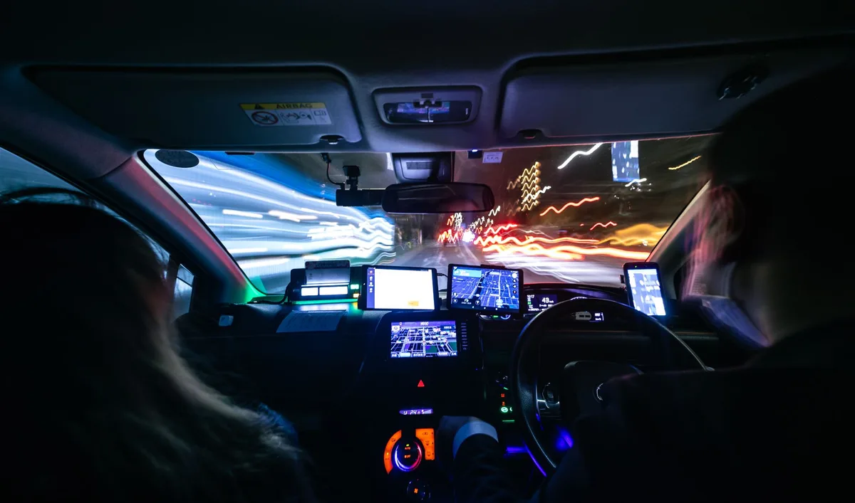 Un passager indique la direction au conducteur sur une route ensoleillée