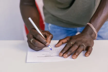 Main tenant dans une main un document cadastral avec une loupe, isoloir flou en arrière-plan