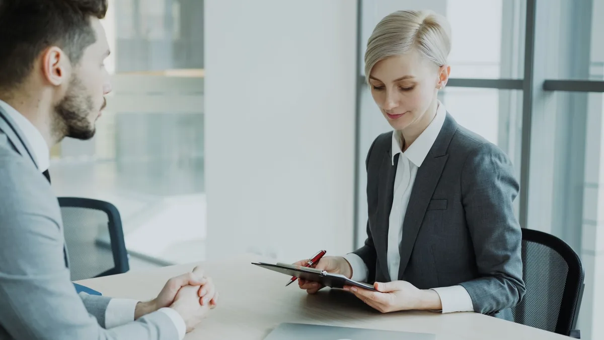 Entretien d'embauche entre un candidat mature et un recruteur dans un bureau moderne