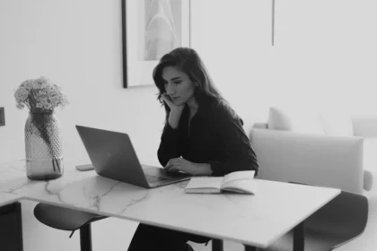 Personne travaillant sur un bilan de compétences à son bureau avec documents et ordinateur portable.