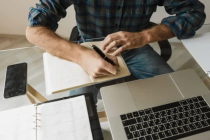 Personne travaillant sur son ordinateur portable avec un calendrier et des notes de recherche d'emploi