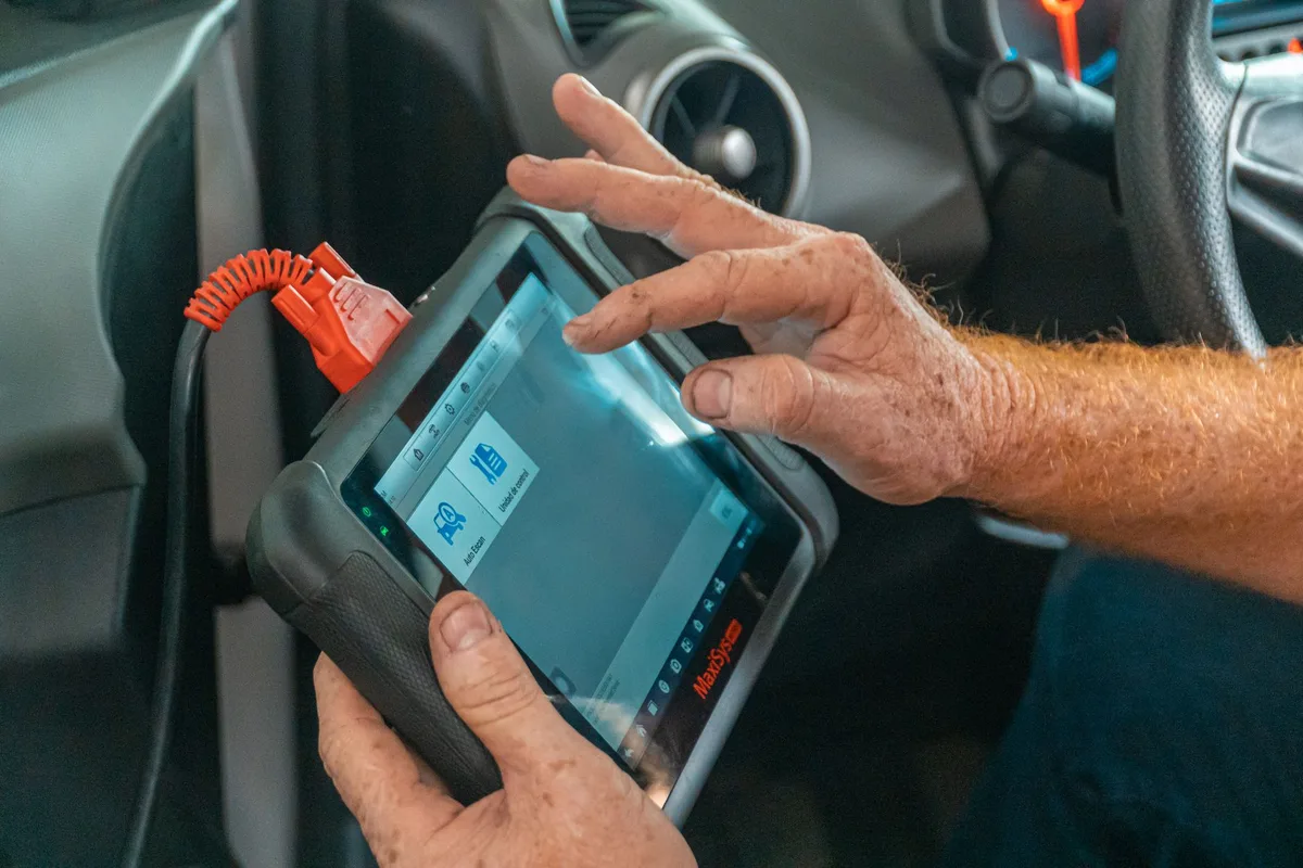 Diagnostic électronique d'une voiture avec scanner dans un atelier professionnel.