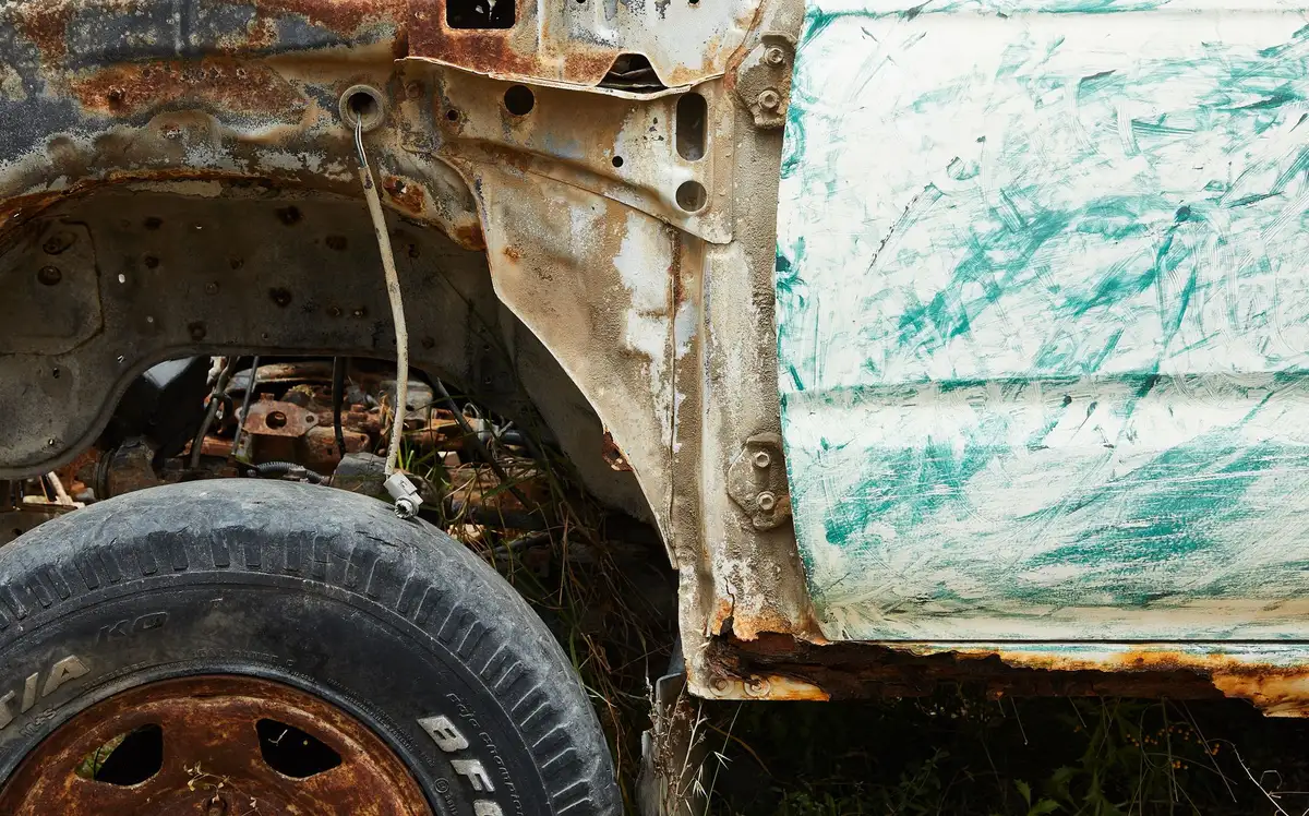 Inspection visuelle d'une voiture présentant des signes d'usure et de corrosion.