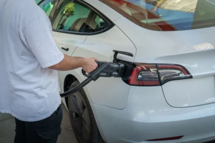 Gros plan sur un câble de recharge inséré dans le port d'une voiture électrique la nuit