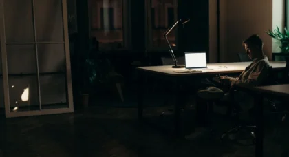 Employé travaillant tard le soir au bureau avec horloge murale visible