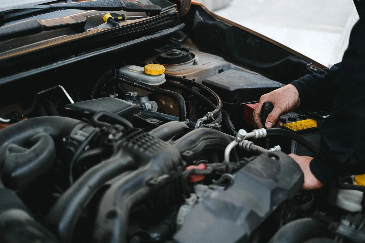 V&eacute;rification de l'entretien d'une voiture avant un long trajet d'automne, avec pneus et batterie