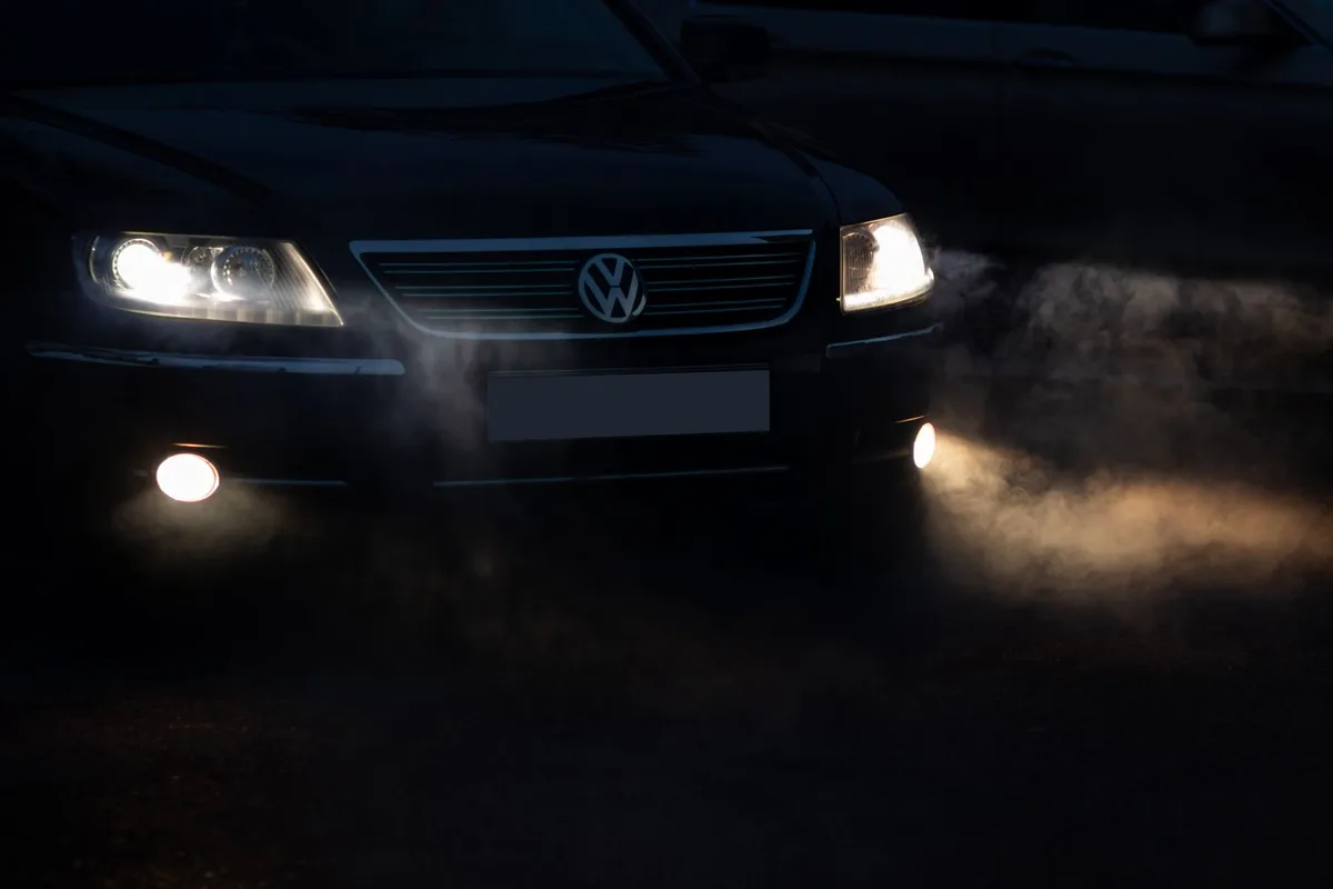 Route de campagne la nuit avec brouillard et feux de v&eacute;hicule