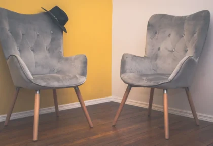 Salon chaleureux avec canapé en velours bordeaux, meuble en bois, accents métalliques et accessoires sculptés.