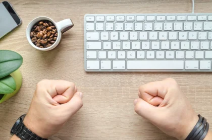 Mains tenant une lettre de rejet et un CV sur un bureau avec une tasse de café