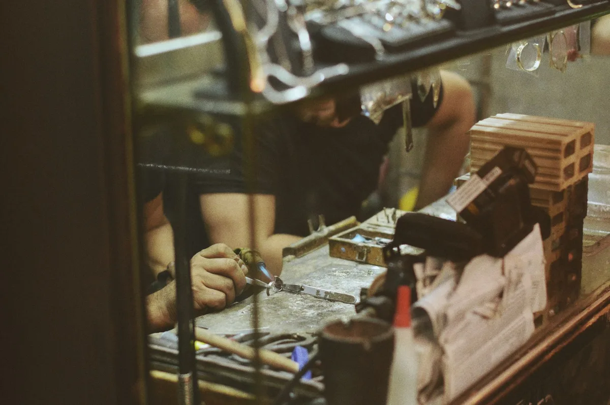 Atelier de fabrication artisanale montrant le travail pr&eacute;cis du laiton et des m&eacute;taux nobles