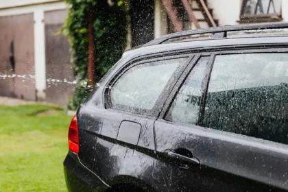 Lavage manuel d'une voiture avec un gant microfibre et un seau d'eau savonneuse