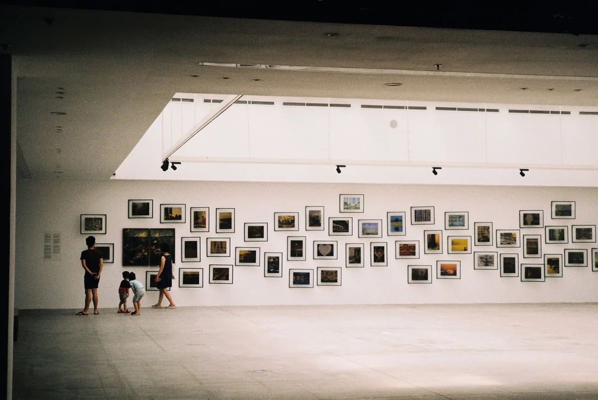 Murs de galerie avec &oelig;uvres d'art moderne &eacute;clair&eacute;es par un mobilier &eacute;pur&eacute; et minimaliste