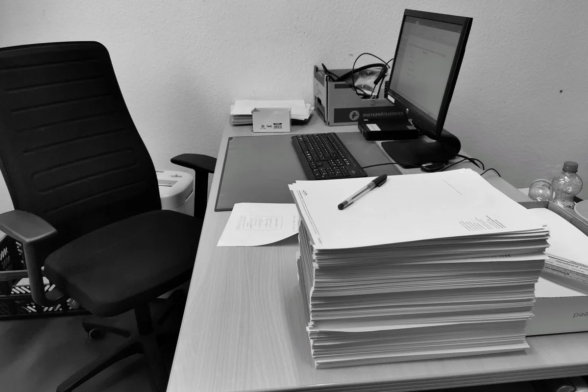 Dossiers administratifs et permis de construire empil&eacute;s sur un bureau
