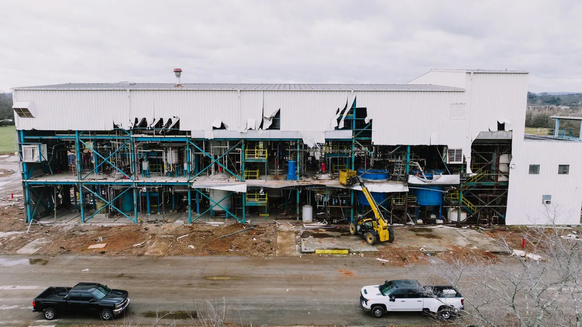 Atelier ou usine après incendie montrant machines endommagées et stocks détruits.