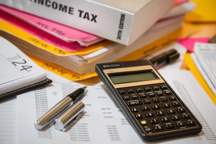 Documents fiscaux et papiers d'immatriculation sur un bureau avec calculatrice
