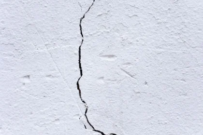 Inspection d'un bien immobilier : fissures et infiltrations d'eau visibles sur un mur intérieur