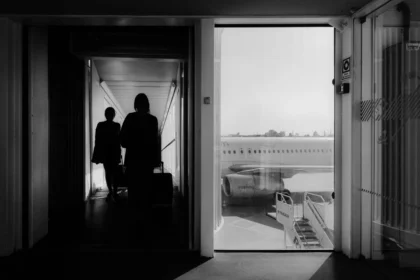 Passager tenant sa carte d'embarquement et son téléphone à la porte d'embarquement de l'aéroport