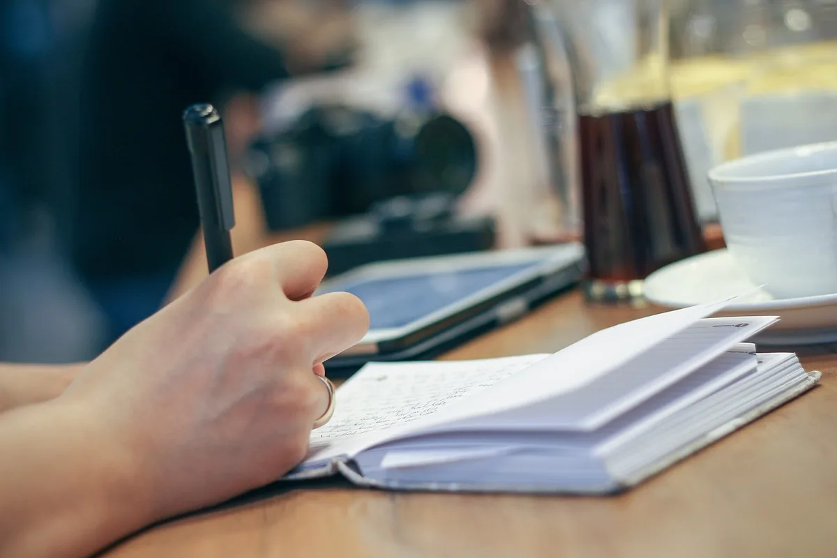 Personne tenant un journal pour analyser ses expériences professionnelles et ses émotions
