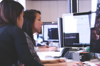 Professionnel réfléchissant face à des défis au travail, entouré de documents sur son bureau