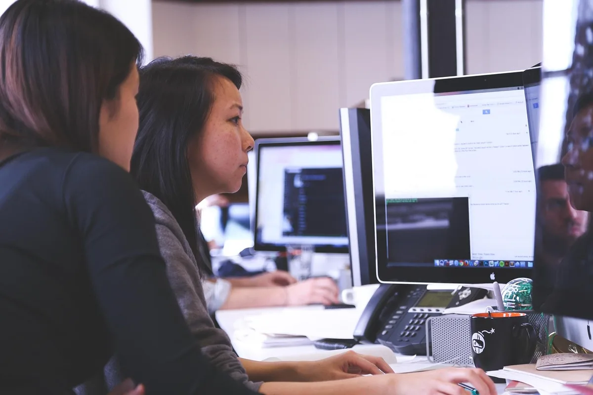 Professionnel réfléchissant face à des défis au travail, entouré de documents sur son bureau