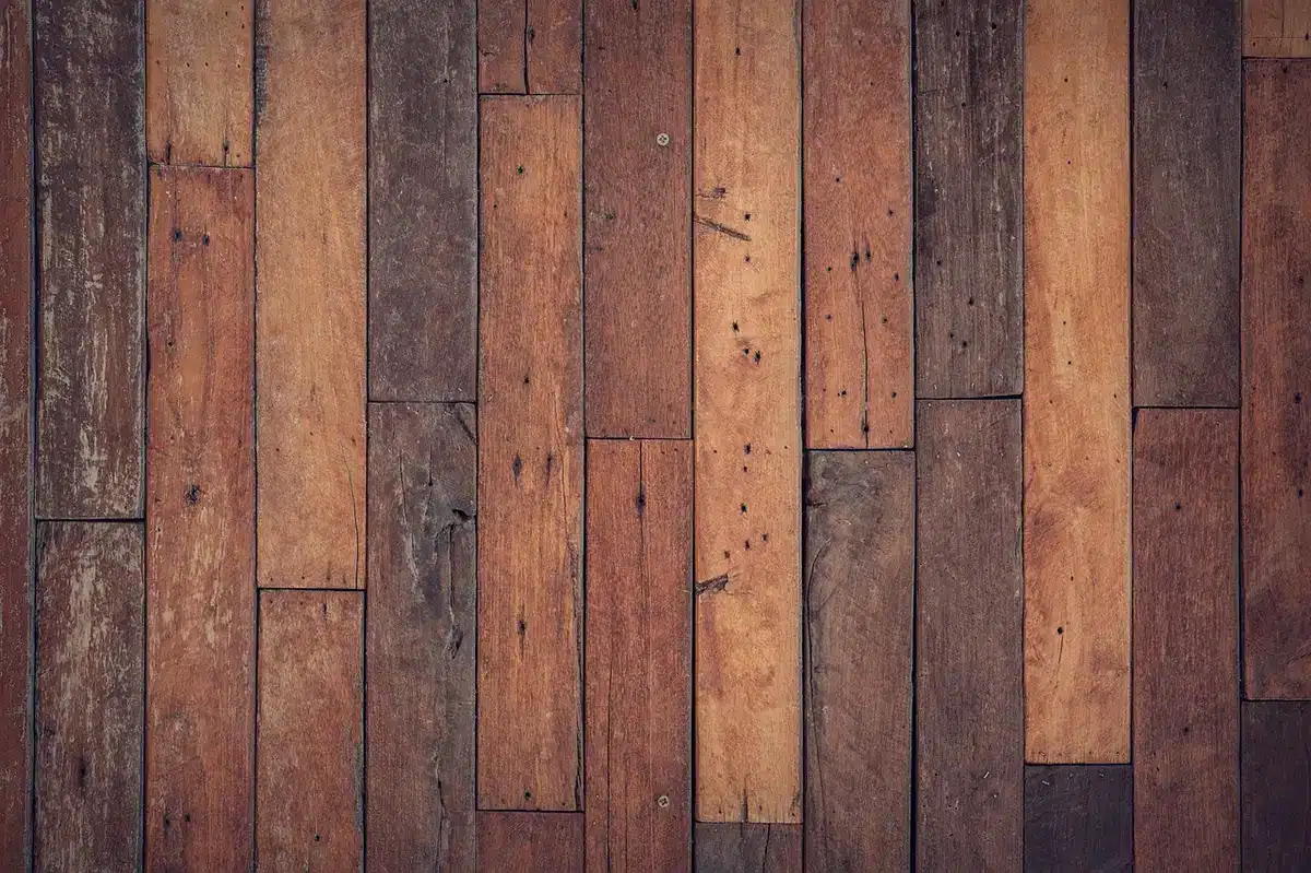 Détail de structure en béton brut contrastant avec un plancher en bois chaleureux dans un intérieur rénové