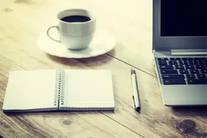 Bureau en journée avec CV, carnet et mains organisant des documents
