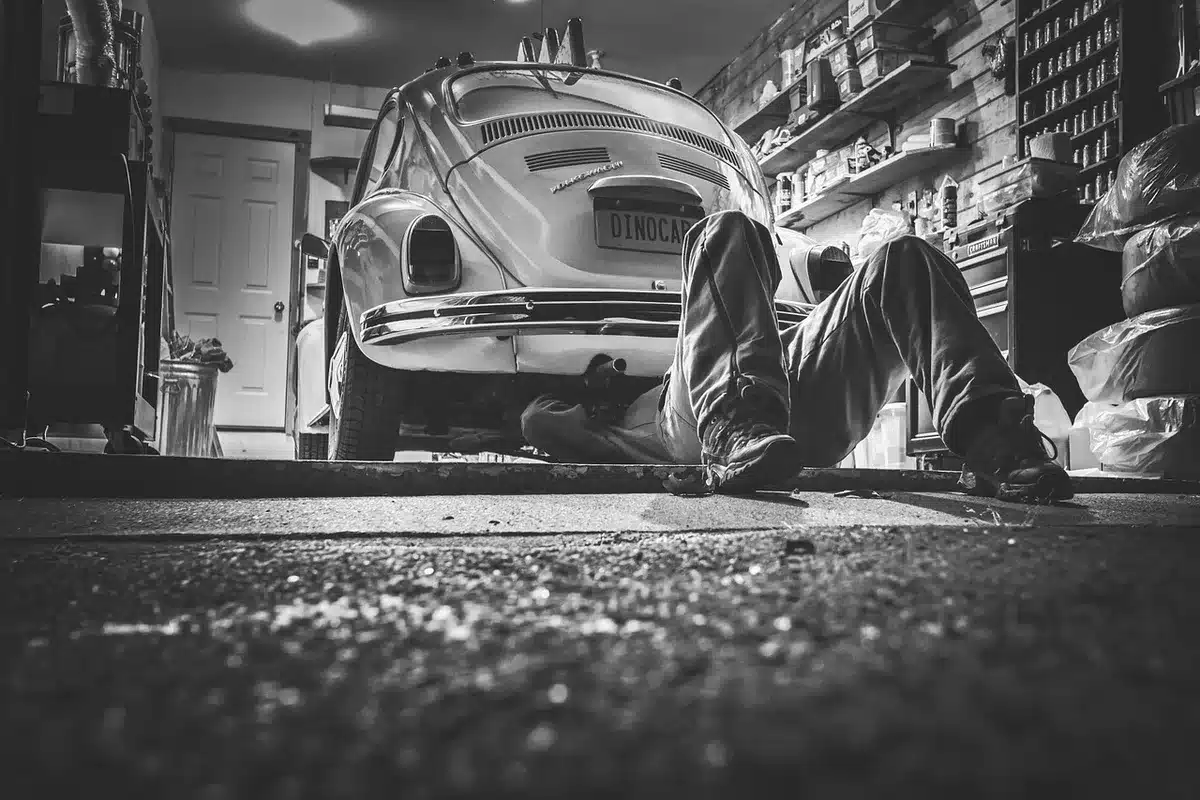 M&eacute;canicien inspectant le syst&egrave;me d'injection d'une voiture en atelier