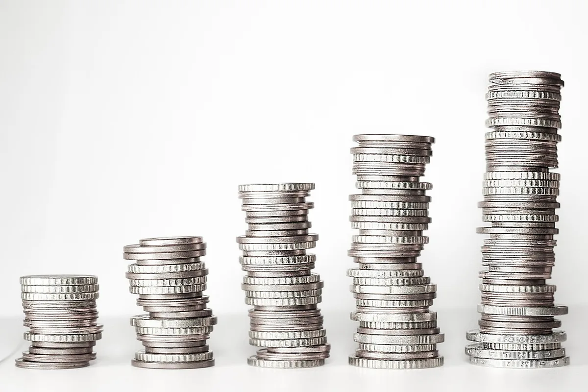 Accumulation d'épargne et pièces de monnaie symbolisant l'apport personnel nécessaire