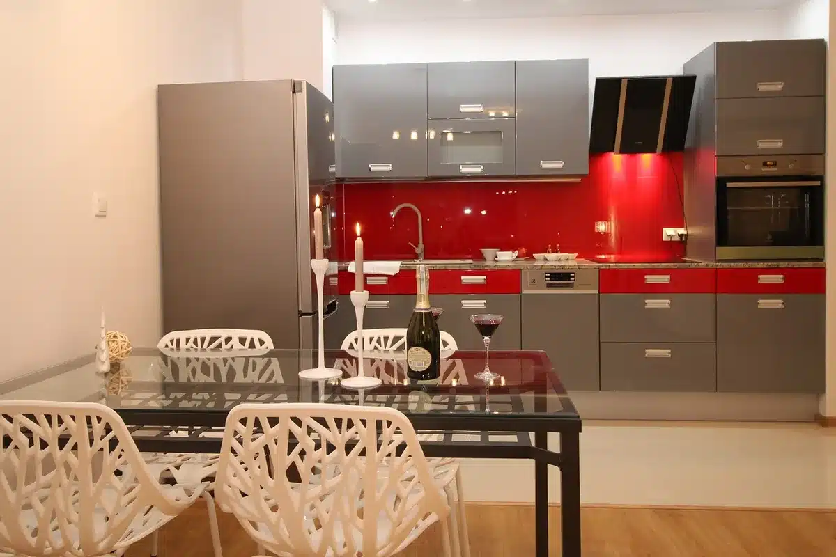 Cuisine rénovée d'un appartement haussmannien avec îlot central en bois, façades claires et verrières.