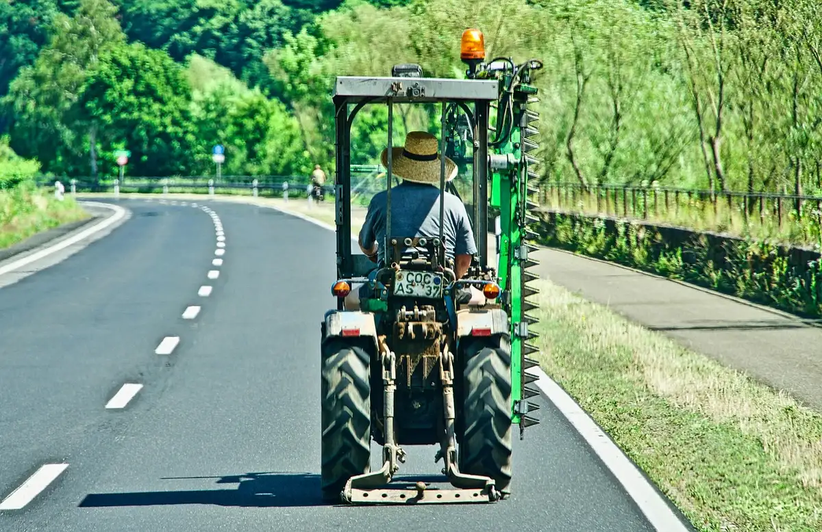 Cortège de tracteurs et agriculteurs sur une route en pleine journée