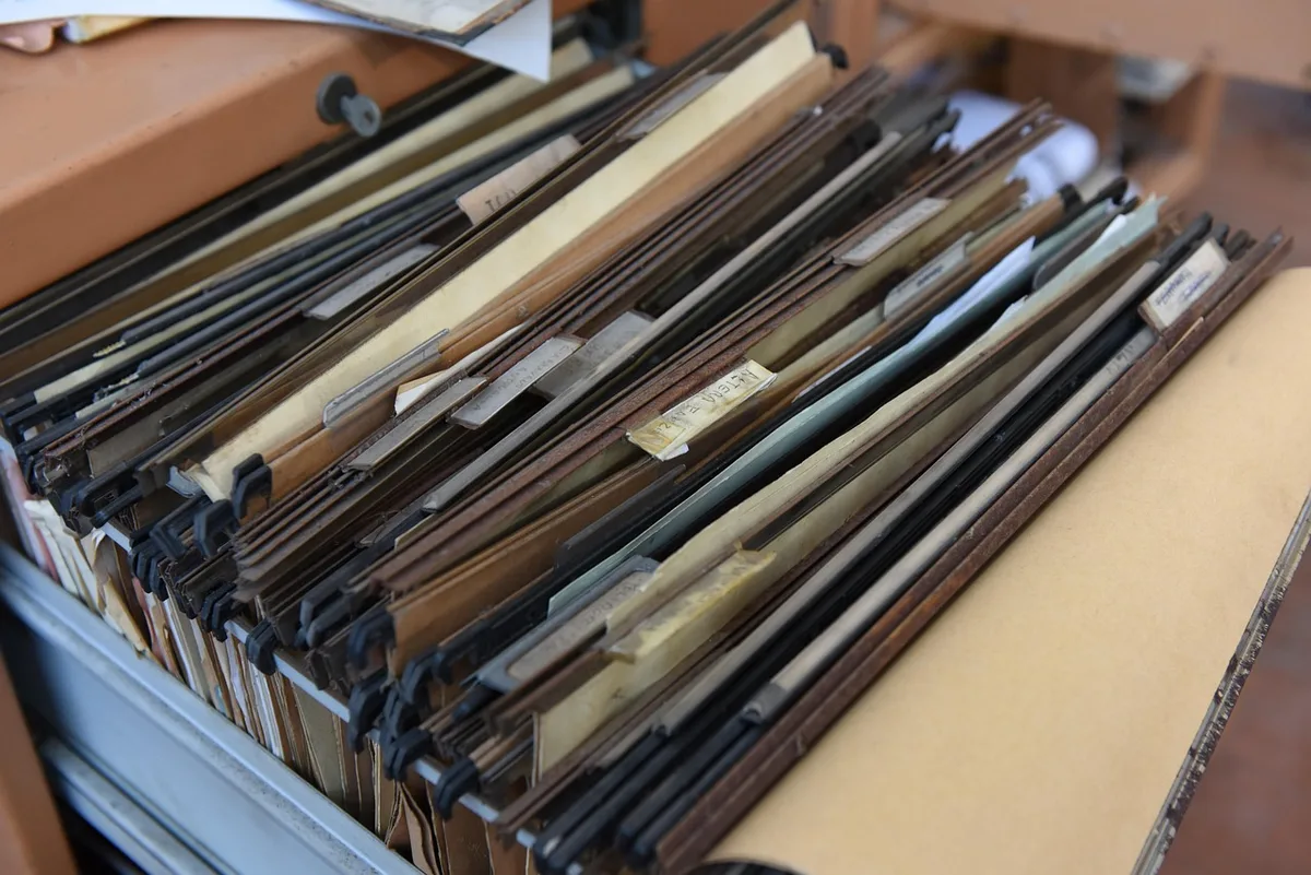 Documents de conformité et contrats empilés sur un bureau professionnel