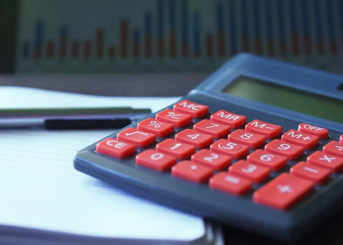 Calculatrice et fiches de paie illustrant le calcul de la contribution patronale