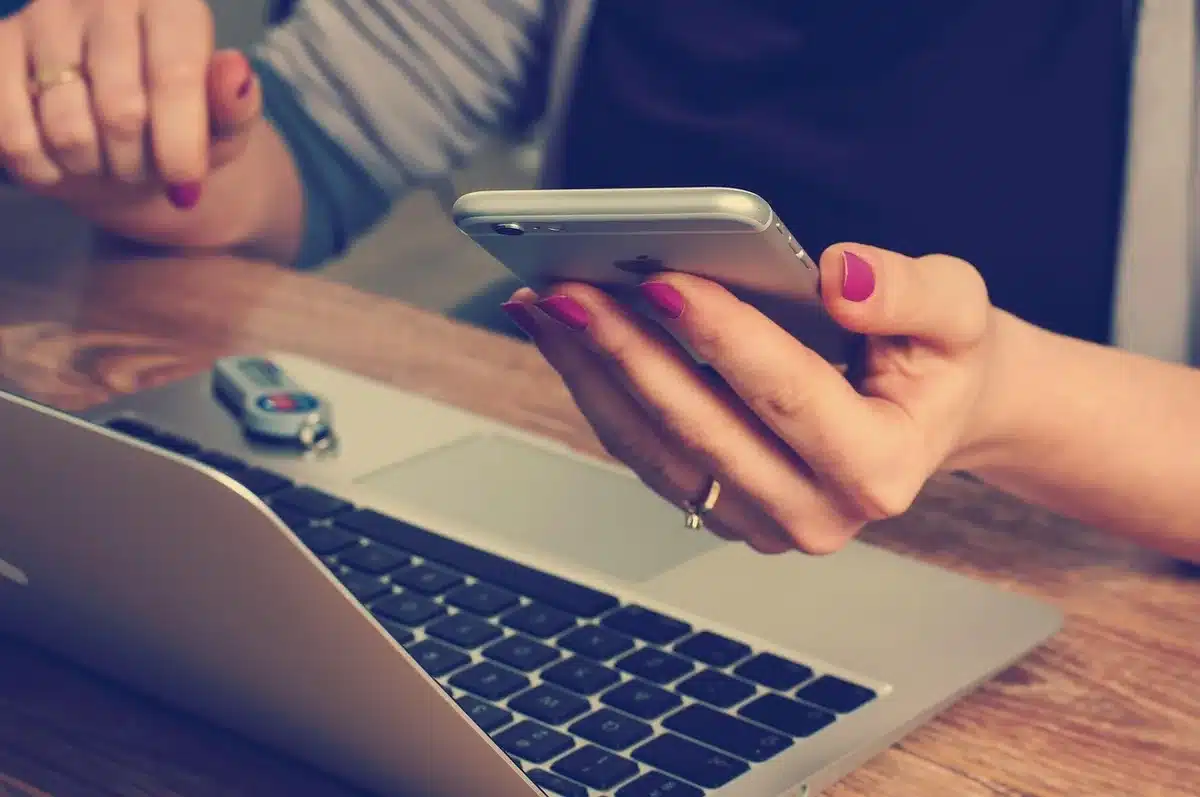 Mains réécrivant un CV sur un bureau clair pour simplifier les intitulés de poste