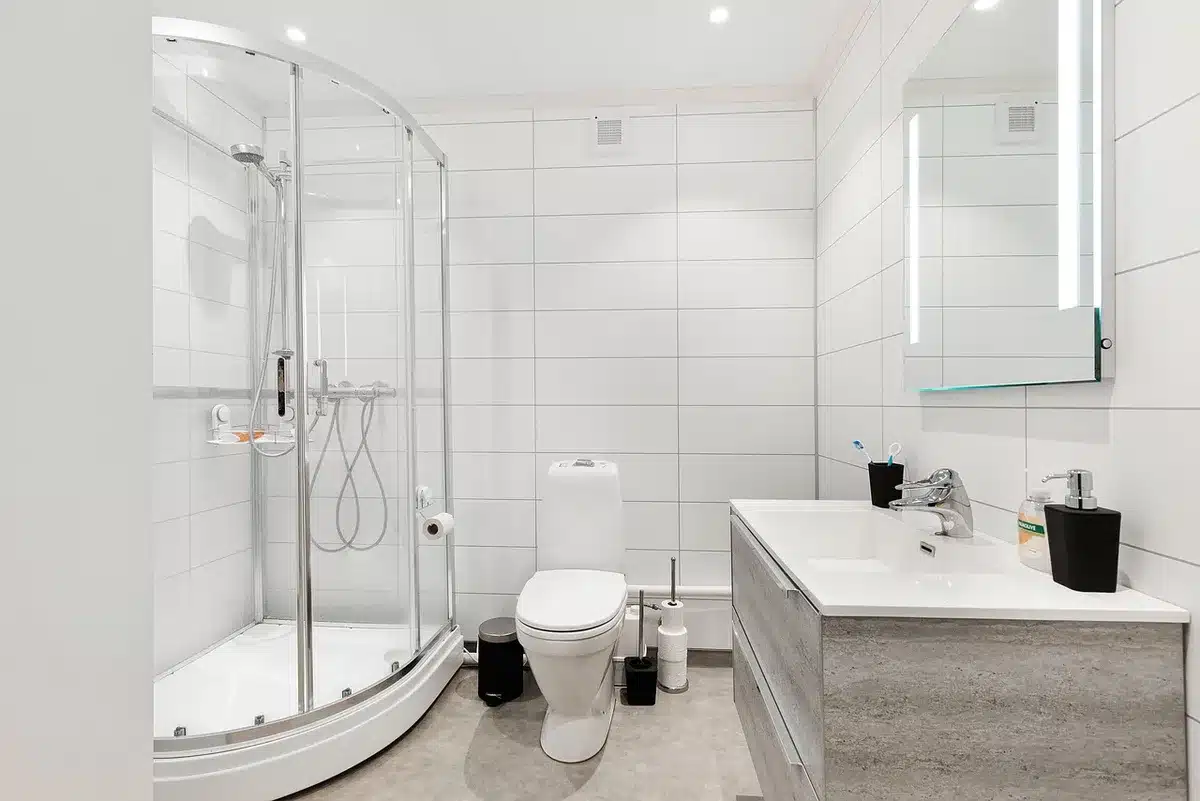Trois éléments de robinetterie de douche disposés sur un plan de travail