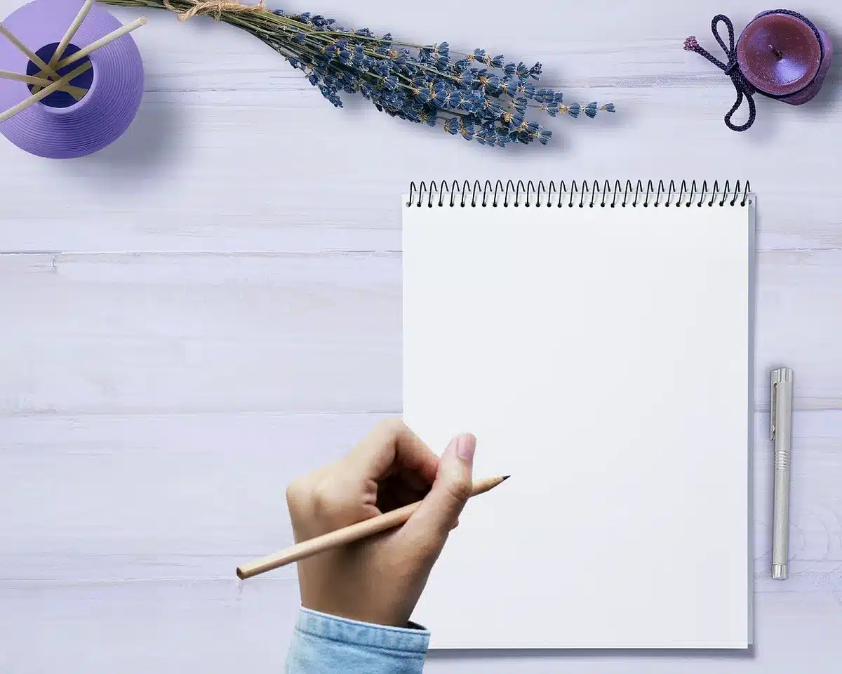 Personne prenant des notes dans un carnet pour repérer ses injonctions intérieures
