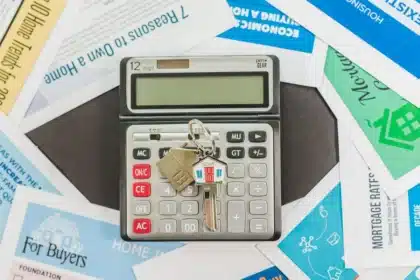 Mains tournant des documents de prêt sur un bureau lumineux avec calculatrice