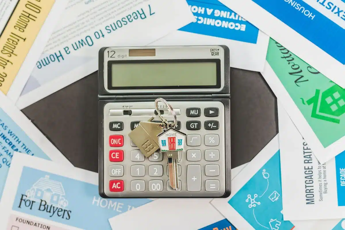 Mains tournant des documents de prêt sur un bureau lumineux avec calculatrice