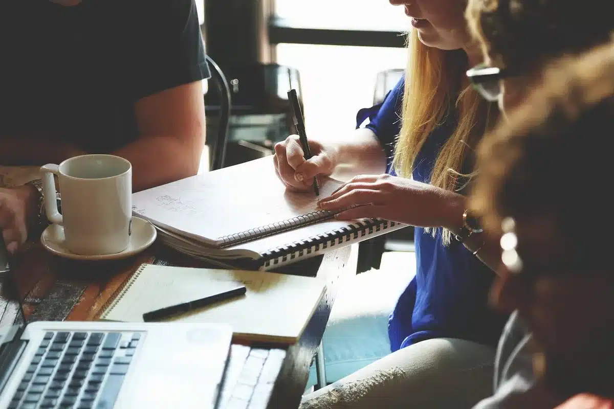 Deux collègues discutant d'horaires de travail devant un bureau ensoleillé