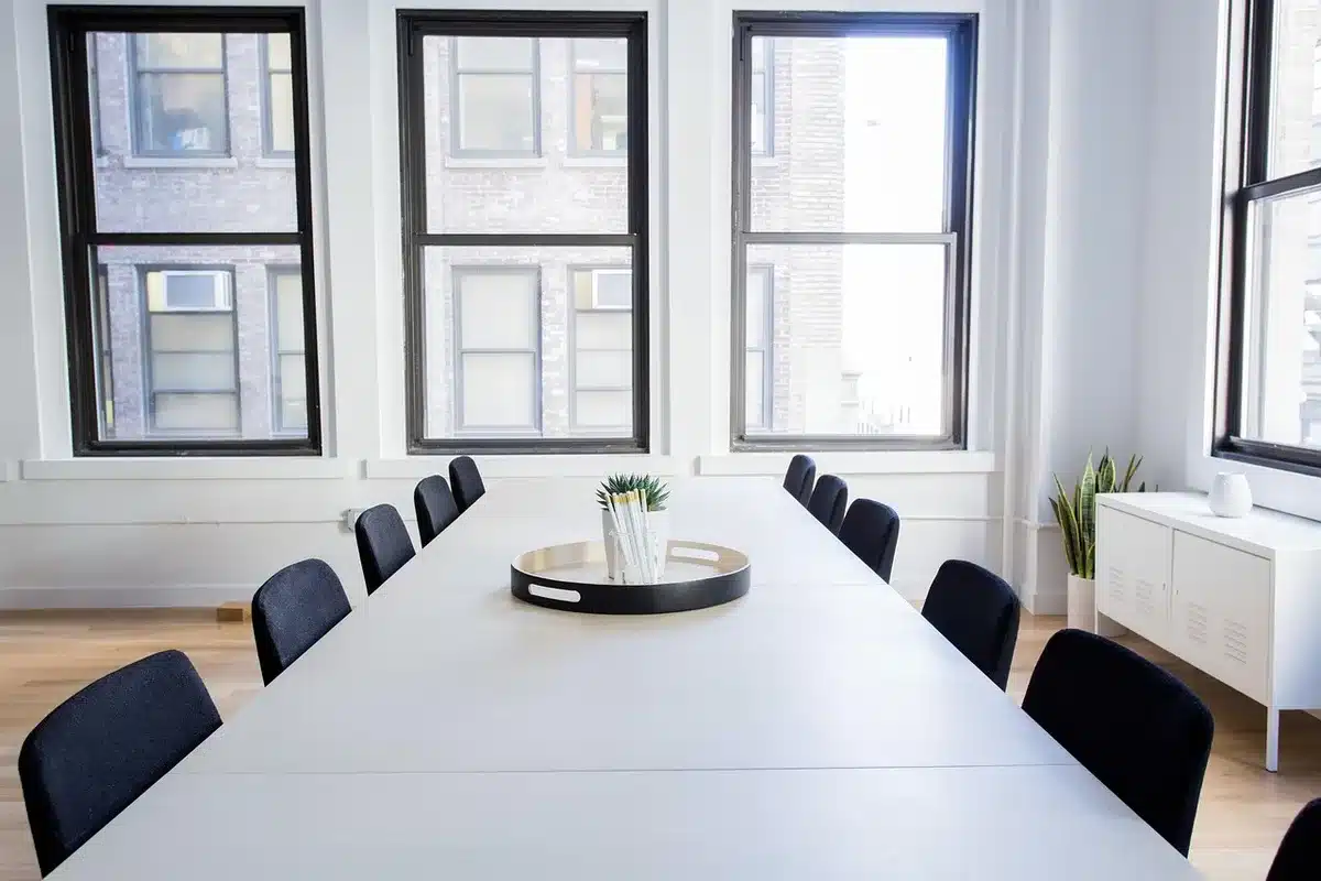 Maines anonymes et dossiers RH sur une table de réunion en plein jour