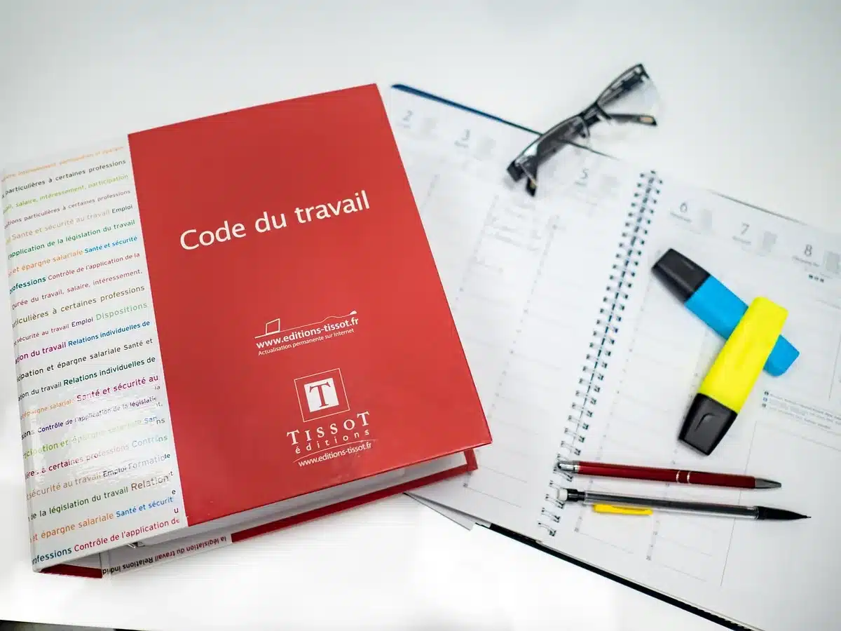 Manuel de formation ouvert sur un bureau avec notes et stylo