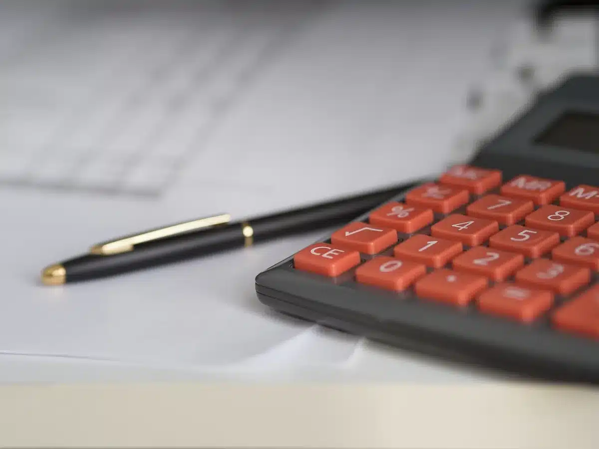 Calculatrice et fiches de paie sur un bureau en pleine journée