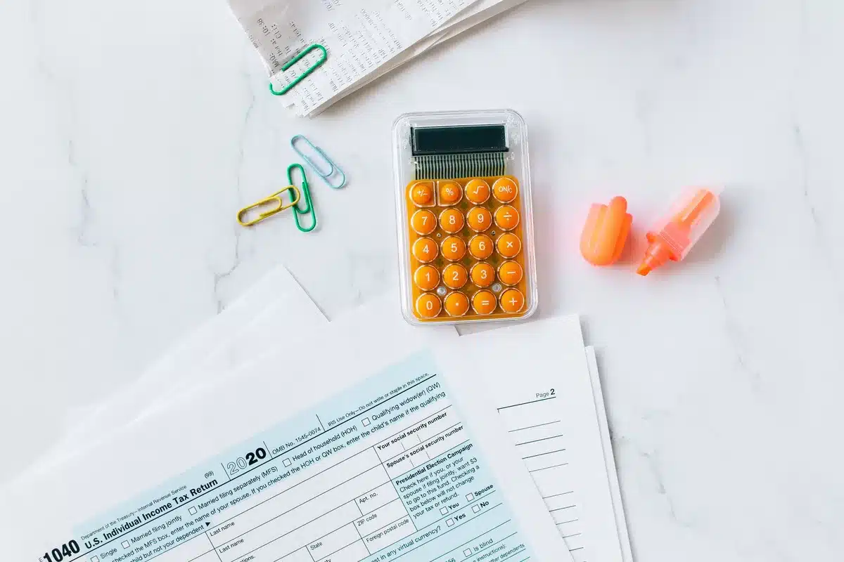 Documents fiscaux et calculatrice sur un bureau, illustrant pression fiscale