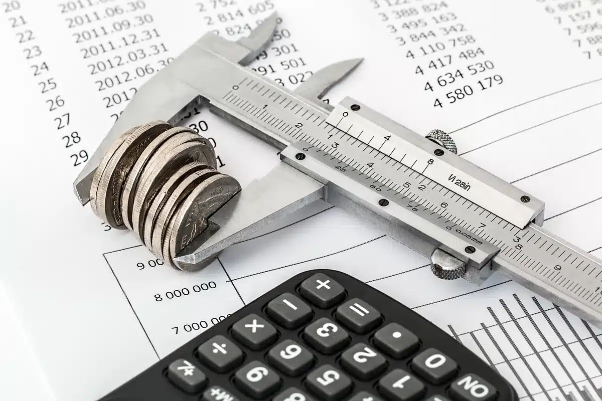 Documents de budget automobile avec calculatrice et clés sur une table en lumière du jour