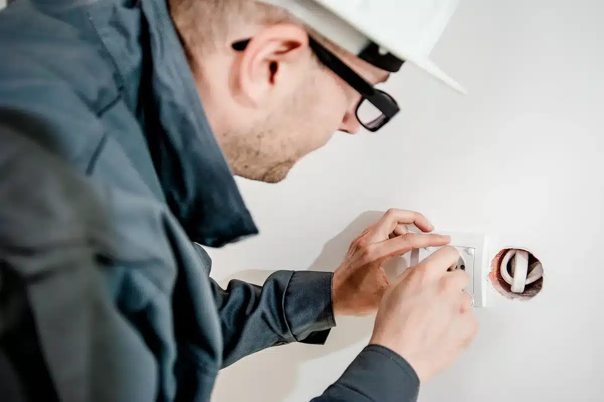 Électricien travaillant sur une borne de recharge avec boîte à outils
