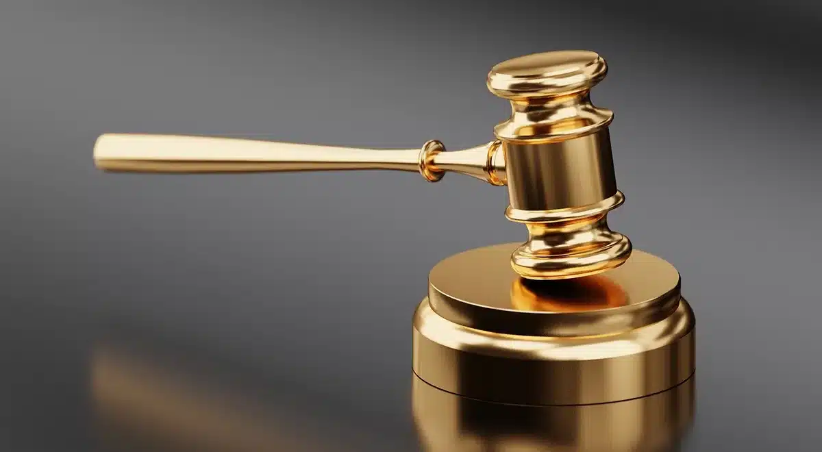Salle d'audience en journée avec un marteau de justice sur une table