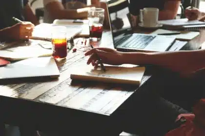 Bureau en journée : feuille de paie, calculatrice et documents sur un bureau lumineux